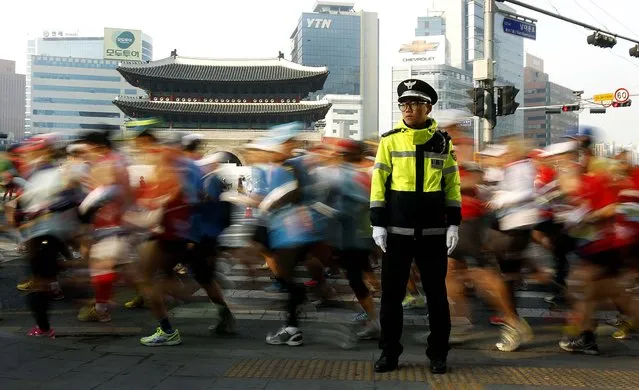 Runners pass by Nam Dae Moon Gate during the men's race of the Seoul International Marathon, on March 17, 2013. (Photo by Ahn Young-joon/Associated Press)