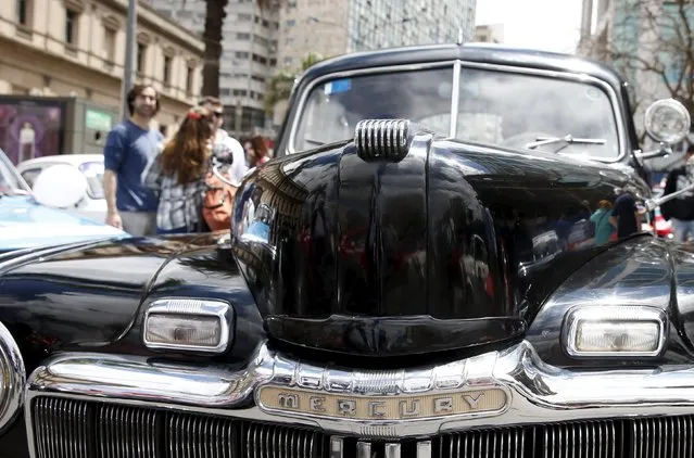 People observe a 1947 Mercury during the 25th edition of the "1000 millas sport e historicos" (1000 miles sports and classic) race in Montevideo, October 28, 2015. (Photo by Andres Stapff/Reuters)