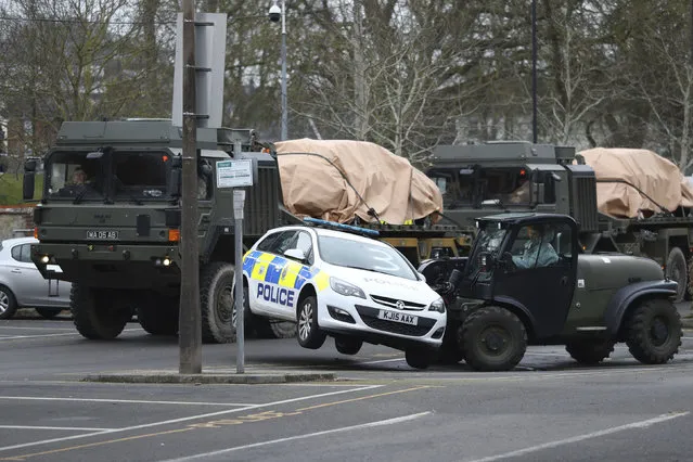 A police car is removed by military personnel from a car park in Salisbury, England, as police and members of the armed forces probe the suspected nerve agent attack on Russian double agent spy Sergei Skripal, Sunday March 11, 2018.  British government security ministers held an emergency meeting Saturday to discuss the poisoning of former spy Skripal and his daughter Yulia, as investigations continue. (Photo by Andrew Matthews/PA Wire via AP Photo)