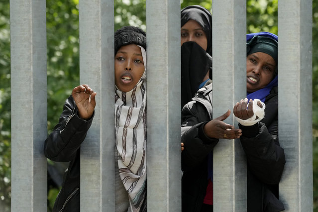 A view of migrants behind the metal barrier border that Poland has erected along the border with Belarus, in Bialowieza Forest, on Wednesday, May 29, 2024. Poland says neighboring Belarus and its main supporter Russia are behind a surging push by migrants in Belarus toward the European Union. (Photo by Czarek Sokolowski/AP Photo)