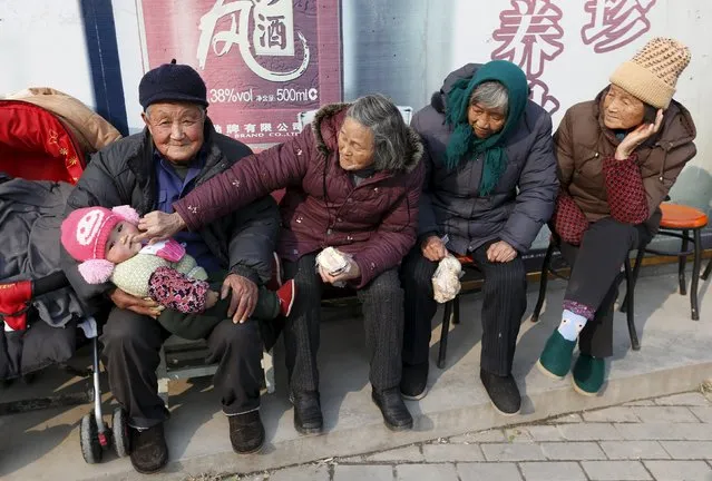 An elderly couple feed their great-grandson with a piece of cake as they sit under the sun in winter in Jiaxing, Zhejiang province, China, in this January 9, 2013 file photo. China will ease family planning restrictions to allow all couples to have two children after decades of the strict one-child policy, the ruling Communist Party said on October 29, 2015, a move aimed at alleviating demographic strains on the economy. (Photo by William Hong/Reuters)