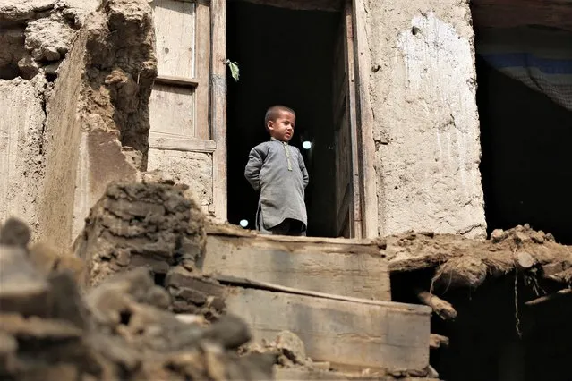 A boy looks out from his damaged home in Miya village, in Alishing District of Laghman Province on March 22, 2023, following an overnight earthquake. At least 13 people were killed in Afghanistan and Pakistan by a strong earthquake felt across thousands of kilometres, but the region appeared on March 22 to have dodged the mass casualties usually associated with a tremor of such scale. (Photo by Shafiullah Kakar/AFP Photo)