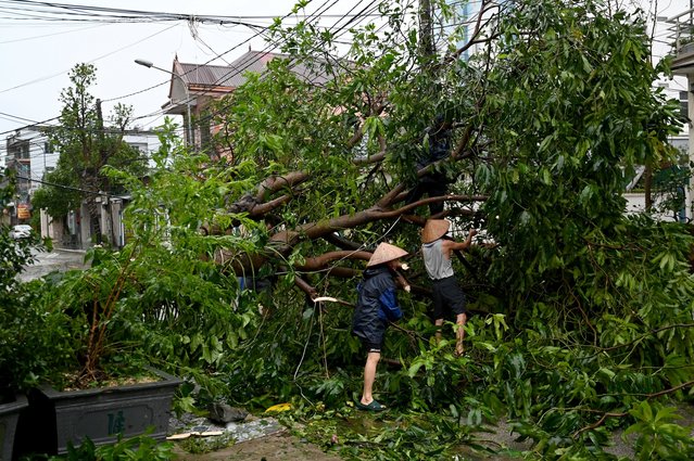 People clear up rubbles after Typhoon Kajiki passed through in Nghe An province on August 26, 2025. (Photo by Nhac Nguyen/AFP Photo)
