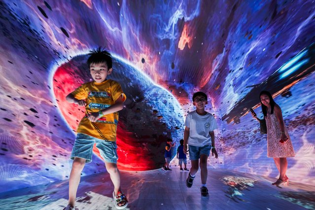 Purawish Bunyagarn, 7 and other children attend “Space & Time Cube +”, a cutting‑edge immersive art and metaverse-inspired experience, in Bangkok, Thailand, on July 23, 2025. (Photo by Chalinee Thirasupa/Reuters)