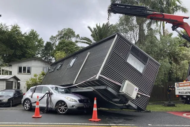 A portable building rests on a car after flood water shifted the structure in Auckland, Saturday, January 28, 2023. Record levels of rainfall pounded New Zealand's largest city, causing widespread disruption. (Photo by Elizabeth Binning/New Zealand Herald via AP Photo)