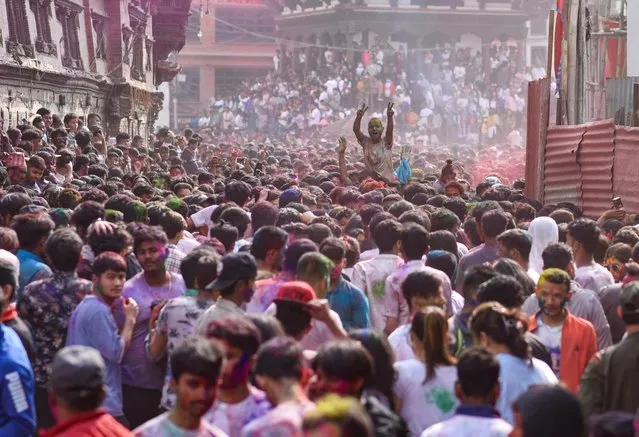 People gather to celebrate Holi, the Festival of Colours at Bashantapur Durbar Square in Kathmandu, Nepal on March 06, 2023. (Photo by Monika Malla/Reuters)