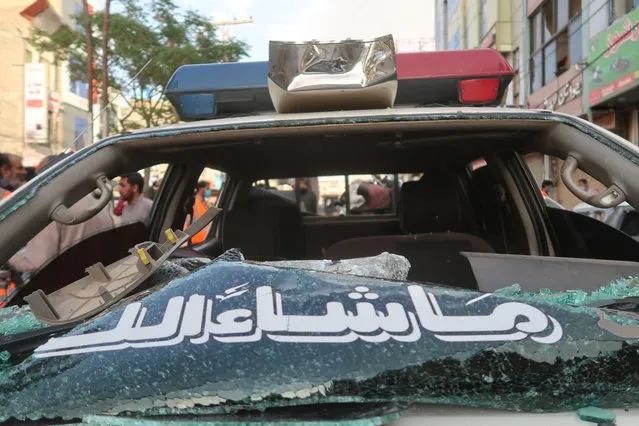 A damaged police car as Pakistani security officials inspect the scene of a blast in Quetta, the provincial capital of Baluchistan, Pakistan, 10 April 2023. At least four people have been killed and six injured in a bombing targeting a police vehicle, police said. (Photo by Fayyaz Ahmad/EPA/EFE)