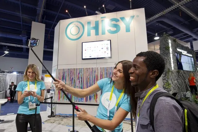 Christine Unruh takes a “selfie” with Kelechi Okorie of Nigeria using a selfie stick and a HiSY bluetooth camera remote during the 2015 International Consumer Electronics Show (CES) in Las Vegas, Nevada January 6, 2015. (Photo by Steve Marcus/Reuters)