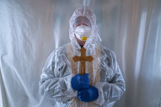 Father Stephan, a Ukrainian Greek Catholic Church priest, wearing a special suit to protect himself against coronavirus, stands, after visiting patients with COVID-19 at an intensive care unit of the emergency hospital in Lviv, Western Ukraine, Saturday, January 9, 2021. Ukraine imposed a wide-ranging lockdown which began Friday, closing schools and entertainment venues and restaurant table service through Jan. 25. (Photo by Evgeniy Maloletka/AP Photo)