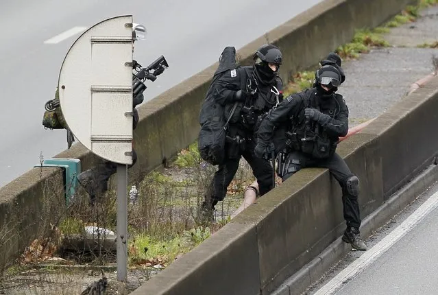 Members of the French police special force advance with their equipment on the Paris ring road near the scene of a hostage taking at a kosher supermarket in eastern Paris January 9, 2015, following Wednesday's deadly attack at the Paris offices of weekly satirical newspaper Charlie Hebdo by two masked gunmen who shouted Islamist slogans. (Photo by Youssef Boudlal/Reuters)