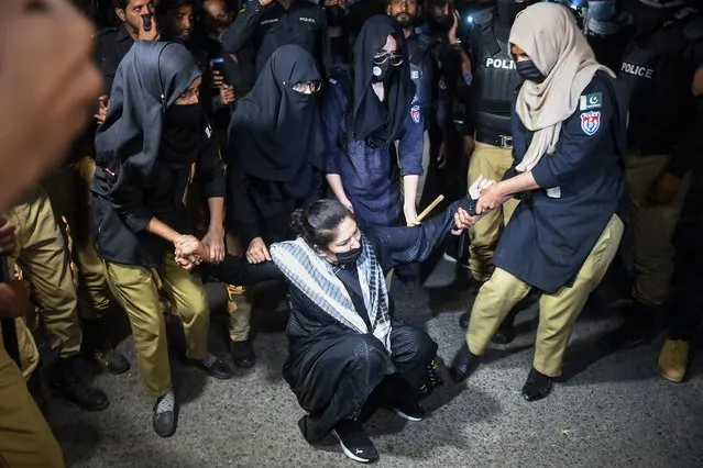 Policewomen detain a Pakistan Tehreek-e-Insaf (PTI) party activist and supporter of former Pakistan's Prime Minister Imran Khan during a protest against the arrest of their leader, in Karachi on May 10, 2023. (Photo by Rizwan Tabassum/AFP Photo)