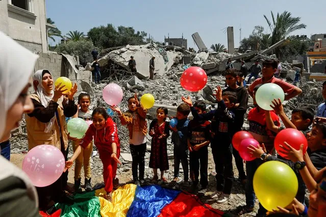 Palestinian children participate in an activity aimed to support the mental health of children affected by the recent Israel-Gaza fighting, near the site of an Israeli strike, after a ceasefire was agreed between Palestinian factions and Israel, in Deir Al-Balah, central Gaza Strip on May 15, 2023. (Photo by Ibraheem Abu Mustafa/Reuters)