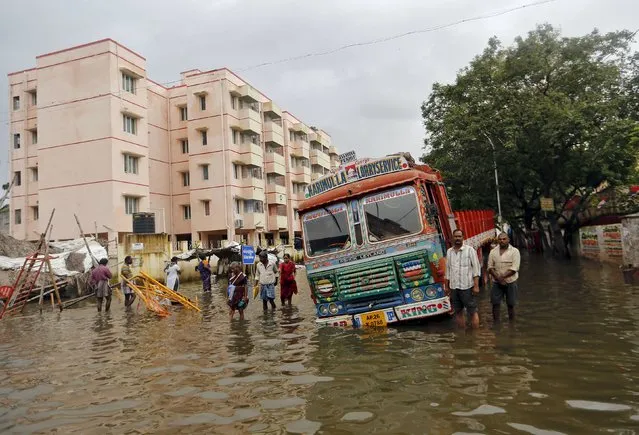 People wade near a stranded truck in a flooded locality in Chennai, India, December 5, 2015. (Photo by Anindito Mukherjee/Reuters)