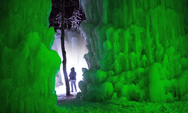 Visitors walk through an ice castle at Stratton Mountain in Stratton, Vermont, USA, 22 January 2015. The ice sculpture is built by hand by harvesting icicles and spraying water in the sub-freezing conditions. (Photo by C. J. Gunther/EPA)
