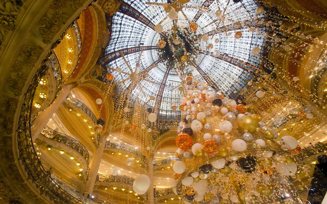 A christmas tree is erected at the center of a Paris department store, Tuesday, December 22, 2015. The decorations are traditionally put up late November each year for Christmas. (Photo by Jacques Brinon/AP Photo)