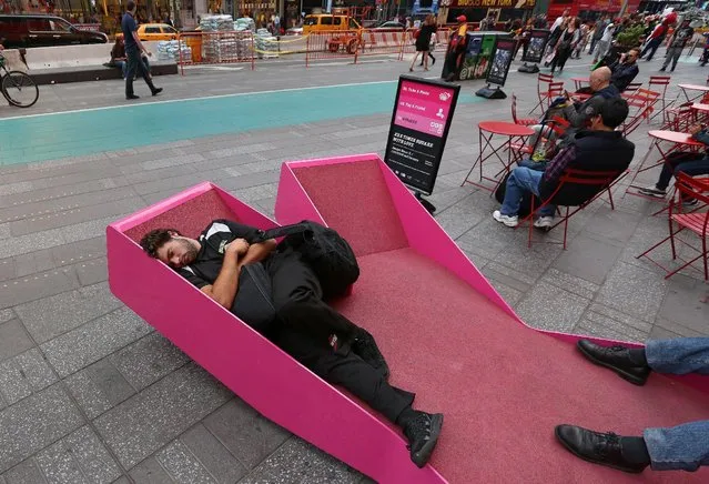 A man sleeps on a bench in the middle of the day in Times Square in the Manhattan borough of New York, New York, U.S., October 20, 2016. (Photo by Carlo Allegri/Reuters)