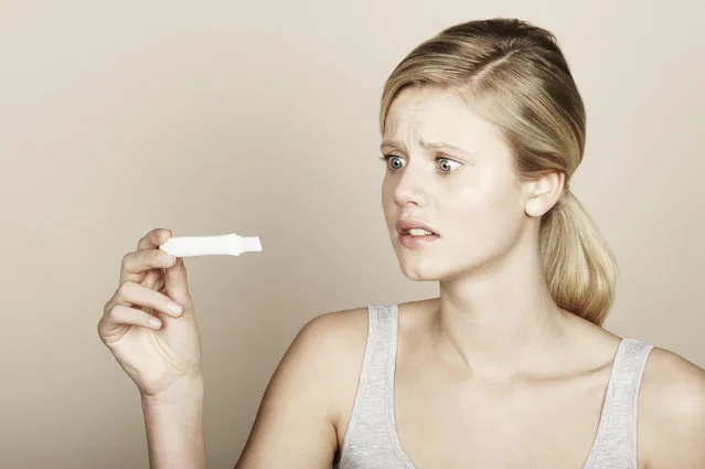 Woman looking at pregnancy test. (Photo by Brand New Images/Getty Images)