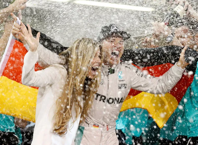 Mercedes driver Nico Rosberg of Germany celebrates with his wife Vivian Sibold holding a German flag in the team garage after winning the F1 2016 Championship in the Emirates Formula One Grand Prix at the Yas Marina racetrack in Abu Dhabi, United Arab Emirates, Sunday, November 27, 2016. (Photo by Ahmed Jadallah/Reuters)