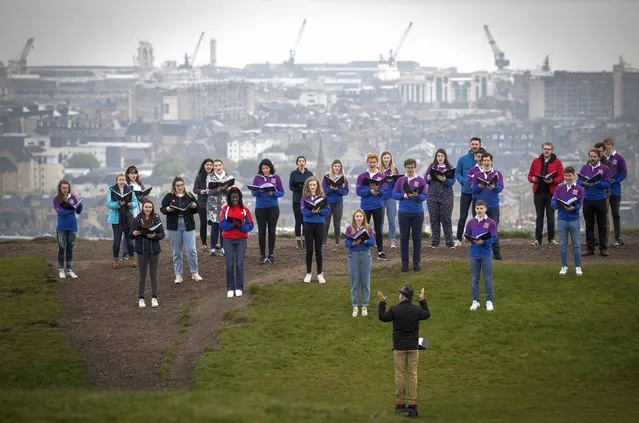 The National Youth Choir of Scotland, with founder and conductor Christopher Bell meet on Calton Hill, to sing, in Edinburgh, Monday May 17, 2021. Most of Scotland moves to Level 2 restrictions enabling up to 30 people to meet outside. The choir last met and performed together in March 2020 which is when the choir last met and performed together. (Photo by Jane Barlow/PA Wire via AP Photo)