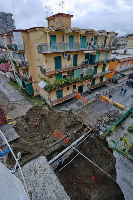 In this photo taken Sunday, February 22, 2015 and made available Monday, February 23 view from above of the chasm that opened Saturday and enlarged in the night, forcing the evacuation of about 380 people, in the Pianura district of Naples, Italy. (Photo by Ciro Fusco/AP Photo/Ansa)