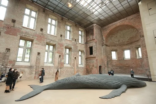 Visitors, limited to 50 at a time as the coronavirus (COVID-19) pandemic continues, look at the sculpture “Cast Whale Project” by Israeli artist Gil Shachar in the St. Elisabeth Church (Elisabethenkirche) on May 02, 2021 in Berlin, Germany. The exhibition of the 14-meter (46-foot) cast of the beached humpback whale, found in Lambert's Bay in South Africa in 2018, runs until May 14. (Photo by Adam Berry/Getty Images)