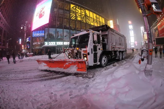 In a photo taken with a fish eye lens, a New York City sanitation vehicle plows the streets in Times Square during a large winter storm in New York City, January 23, 2016. (Photo by Gordon Donovan/Yahoo News)