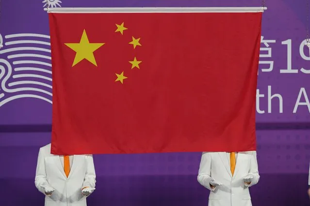 A Chinese national flag is hoisted during a medal ceremony for judo at the 19th Asian Games in Hangzhou, China, Tuesday, September 26, 2023. (Photo by Vincent Thian/AP Photo)