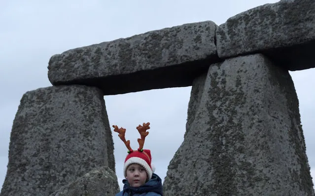 A visitor reacts amongst the prehistoric stones of the Stonehenge monument at dawn on Winter Solstice, the shortest day of the year, near Amesbury in south west Britain, December 21, 2016. (Photo by Toby Melville/Reuters)