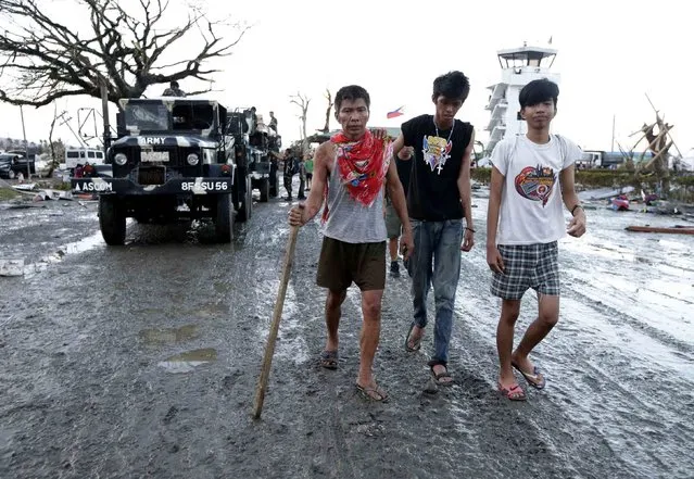 An injured man walks with an aid of a cane to get some treatment following a powerful typhoon that hit Tacloban city, in Leyte province in central Philippines Saturday November 9, 2013. (Photo by Bullit Marquez/AP Photo)