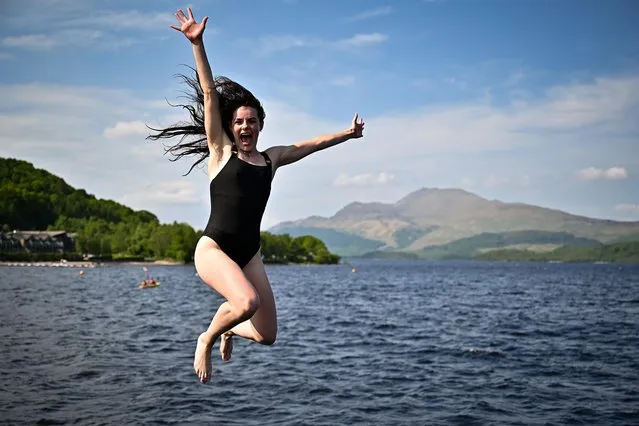 Members of the public enjoy the warm temperatures by jumping off Luss Pier into Loch Lomond on July 2, 2021 in Luss, Scotland. Much of the country is to continue to enjoy warm, sunny weather for the rest of the week according to the latest forecasts from the Met Office. (Photo by Jeff J. Mitchell/Getty Images)