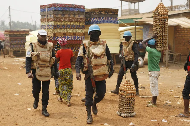 UN peacekeepers from Congo Brazaville walk in the PK5 district after  unloading a truck of its voting material and ballots at a polling station in Bangui, Central African Republic, Saturday February 13, 2016. (Photo by Jerome Delay/AP Photo)