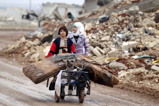 Samah, 11, and her brother, Ibrahim, transport their salvaged belongings from their damaged house in Doudyan village in northern Aleppo Governorate, Syria, January 2, 2017. (Photo by Khalil Ashawi/Reuters)
