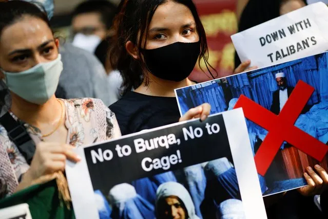 Afghan women hold placards during a protest demanding international community to help Afghan refugees, in New Delhi, India, August 23, 2021. (Photo by Adnan Abidi/Reuters)