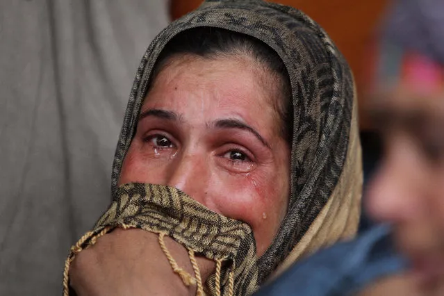 A relative of Abdul Ghani Mir, who was killed in the cross fire between government forces and rebels, cries during his funeral at Pinglan some 38 kilometers (23.75 miles) south of Srinagar, Indian controlled Kashmir Sunday, February 21, 2016. Rebels holed up in a building in the Indian portion of Kashmir exchanged fire with government forces for the second straight day Sunday, leaving a number of people dead and wounded. (Photo by Mukhtar Khan/AP Photo)