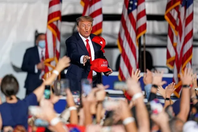Former U.S. President Donald Trump tosses a hat prior to him speaking during a rally in Cullman, Alabama, U.S., August 21, 2021. (Photo by Marvin Gentry/Reuters)