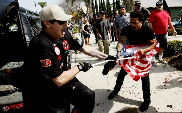 A Ku Klux Klansman, left, fights a counter protester for an American flag after members of the KKK tried to start a “White Lives Matter” rally at Pearson Park in Anaheim on Saturday, February 27, 2016. The event quickly escalated into violence and at least two people had to be treated at the scene for stab wounds. (Photo by Luis Sinco/Los Angeles Times via AP Photo)