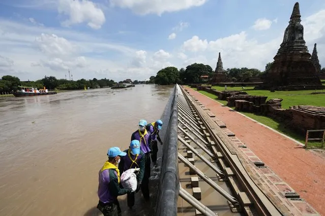 Soldiers stack sandbags to protect Wat Chaiwatthanaram from possible rising flood waters in Ayutthaya province, north of Bangkok, Thailand, Monday, September 27, 2021. Seasonal monsoon rains may worsen flooding that has already badly affected about a third of Thailand, officials said Monday as flood gates and pumping stations were being used to mitigate the potential damage. (Photo by Sakchai Lalit/AP Photo)