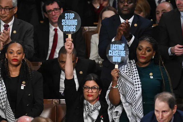(L-R) US Representative Rashida Tlaib, Democrat of Michigan, and US Representative Cori Bush, Democrat of Missouri, hold signs reading “Stop Sending Bombs” and “Lasting Ceasfire Now” as US President Joe Biden delivers the State of the Union address in the House Chamber of the US Capitol in Washington, DC, on March 7, 2024. (Photo by Andrew Caballero-Reynolds/AFP Photo)