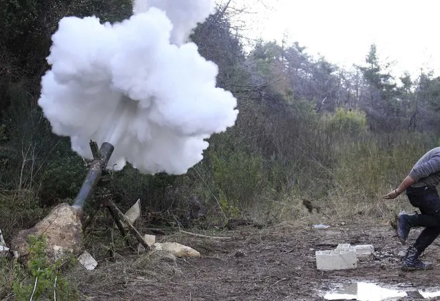 A “Free Syrian Army” fighter runs to take cover after launching a mortar towards forces loyal to Syria's President Bashar al-Assad in the Jabal al-Akrad area in Syria's northwestern Latakia province February 25, 2014. (Photo by Alaa Khweled/Reuters)