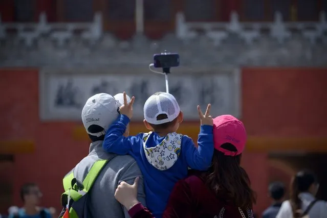 A family uses a selfie stick to take a photo after visiting the Forbidden City in Beijing on May 3, 2015. (Photo by Wang Zhao/AFP Photo)