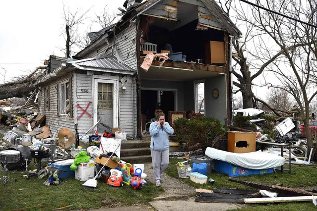 Brittany Oakley checks in with relatives outside of what is left of her home in Lakeview, Ohio., Friday, March 15, 2024. Severe storms with suspected tornadoes have damaged homes and businesses in the central United States. (Photo by Timothy D. Easley/AP Photo)