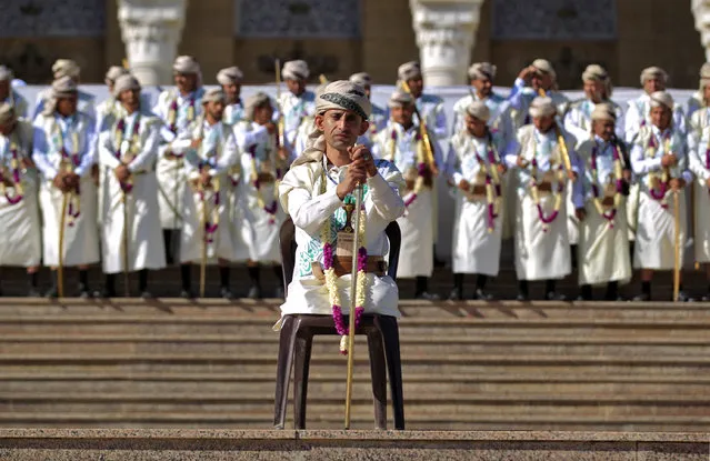 A leg-amputee groom along with others dressed in traditional Yemeni garb attend  a mass wedding for 1000 couples organised by the Huthi-held Zakat authority in Yemen's capital Sanaa on December 2, 2021. (Photo by Mohammed Huwais/AFP Photo)