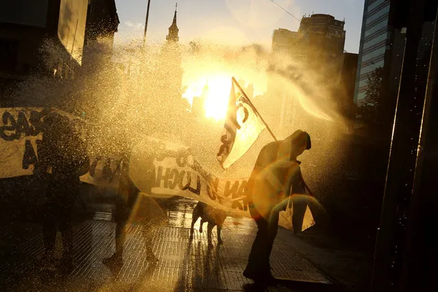 A jet of water is released on protesters during a rally marking the anniversary of the death of union leader Juan Pablo Jimenez, in Santiago, Chile February 21, 2017. (Photo by Ivan Alvarado/Reuters)