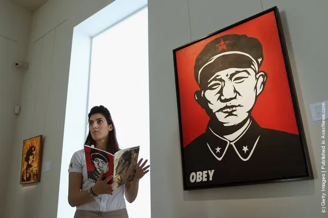 A Bonhams intern stands beside a work entitled 'Chinese Soldier' by Shepard Fairey