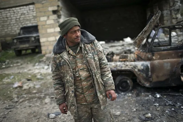 A serviceman of the self-defense army of Nagorno-Karabakh stands next to a destroyed military car in the village of Talish April 6, 2016. (Photo by Reuters/Staff)