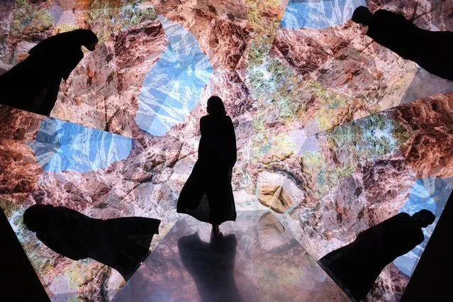 A woman looks at a video installation at a pavillion at the Expo 2020, in the Gulf Emirateof Dubai, on December 1, 2021. (Photo by Giuseppe Cacace/AFP Photo)