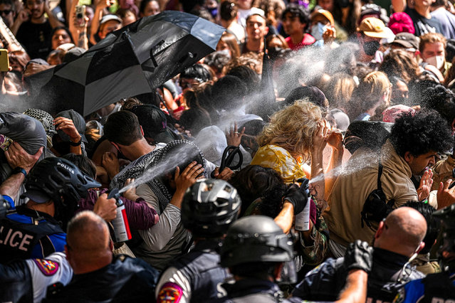 A state trooper pepper sprays pro-Palestinian protesters, during the ongoing conflict between Israel and the Palestinian Islamist group Hamas, after police vehicles were blocked at the University of Texas in Austin, Texas, U.S. April 29, 2024. (Photo by Aaron E. Martinez/American-Statesman/USA Today Network via Reuters)