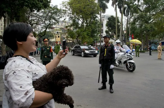 A woman with her pet dog watch as motorcade of North Korean leader Kim Jong Un is driven off Melia hotel in Hanoi, Vietnam, Saturday, March 2, 2019. (Photo by Gemunu Amarasinghe/AP Photo)