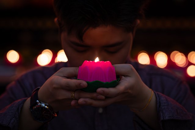 A Buddhist devotee holds an oil lamp in a shape of a lotus flower as he offers prayers during a Lunar New Year celebration at Thean Hou Temple on February 09, 2024, in Kuala Lumpur, Malaysia. Chinese New Year in Malaysia is marked by family gatherings, festive adornments and traditional rituals embodying a spirit of hope and renewal for the year ahead, and aims to bring joy and prosperity to all while fostering a sense of unity and hope for a successful Year of the Dragon. (Photo by Annice Lyn/Getty Images)