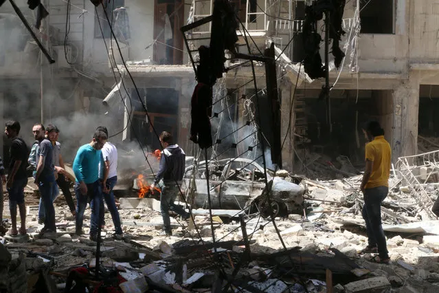 People inspect the damage at a site hit by airstrikes, in the rebel-held area of Aleppo's Bustan al-Qasr, Syria April 28, 2016. (Photo by Abdalrhman Ismail/Reuters)